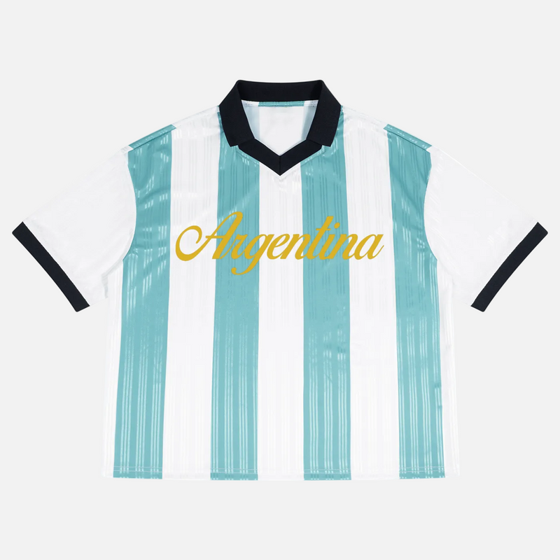 A short-sleeve Argentina soccer jersey with vertical light blue and white stripes, a black V-neck collar, black sleeve trim, and 'Argentina' printed in gold script across the chest, shown on a plain white background.
