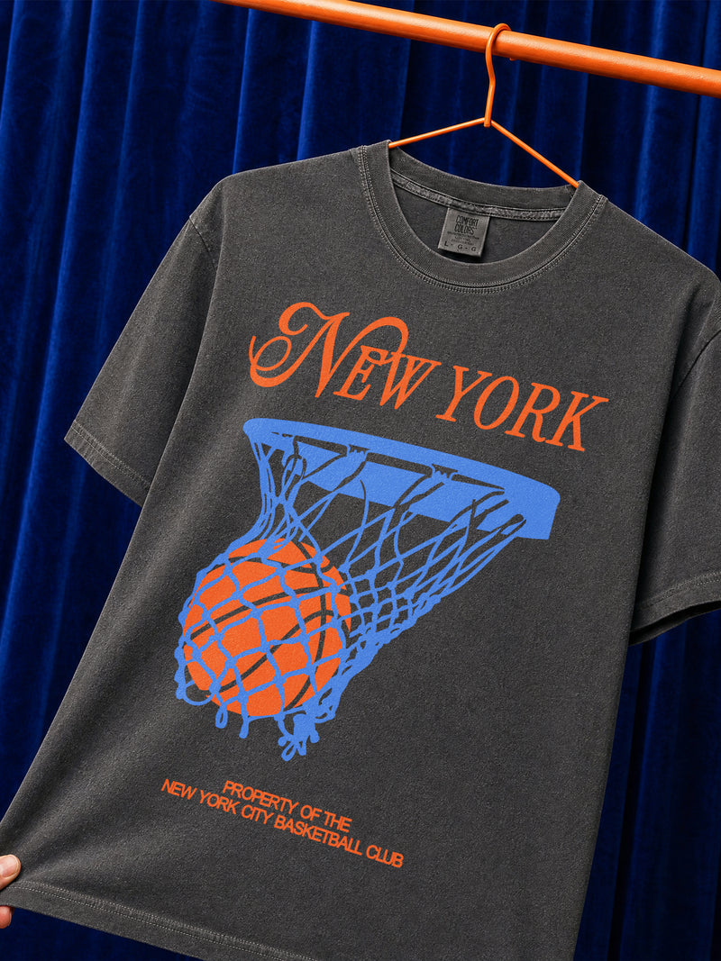 Off white New York Knicks t-shirt with retro orange and royal blue streetwear art and retro jersey lettering on a unisex comfort colors graphic tee