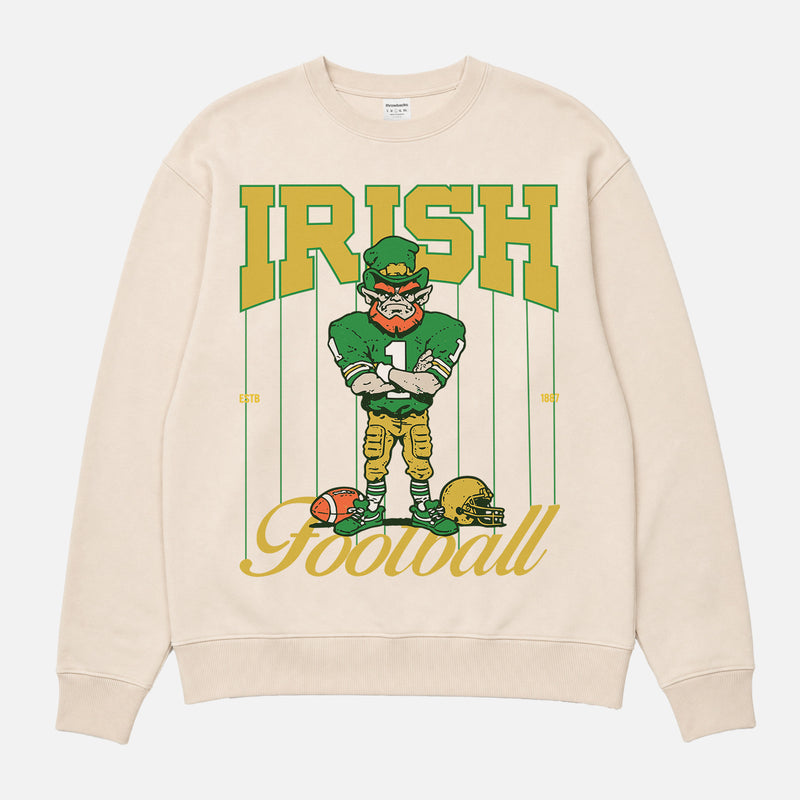 Vintage Notre Dame Fighting Irish crewneck with green and gold leprechaun mascot and retro pinstripes on a beige sweatshirt for men and women
