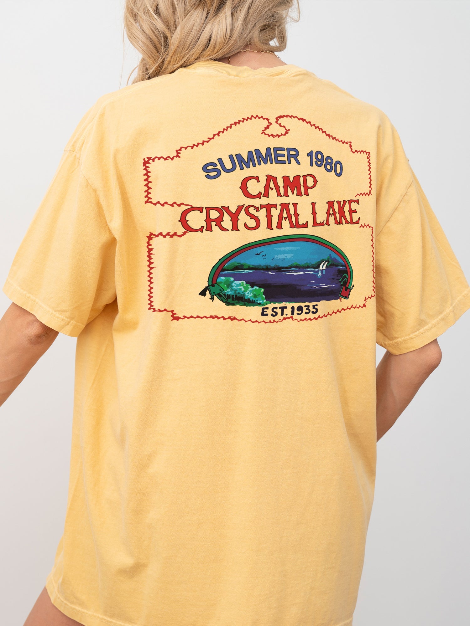 Friday the Thirteenth movie t-shirt with Camp Crystal lake counselor logo on the front and vintage signage on the back of a washed yellow comfort colors shirt for jason voorhees fans