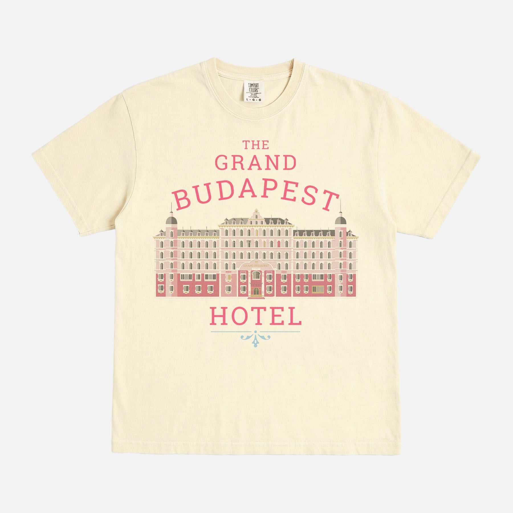 The Grand Budapest Hotel T-Shirt featuring an illustration of the iconic pink hotel façade in Wes Anderson-inspired colors on a soft unisex movie-lover graphic tee.