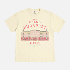 The Grand Budapest Hotel T-Shirt featuring an illustration of the iconic pink hotel façade in Wes Anderson-inspired colors on a soft unisex movie-lover graphic tee.