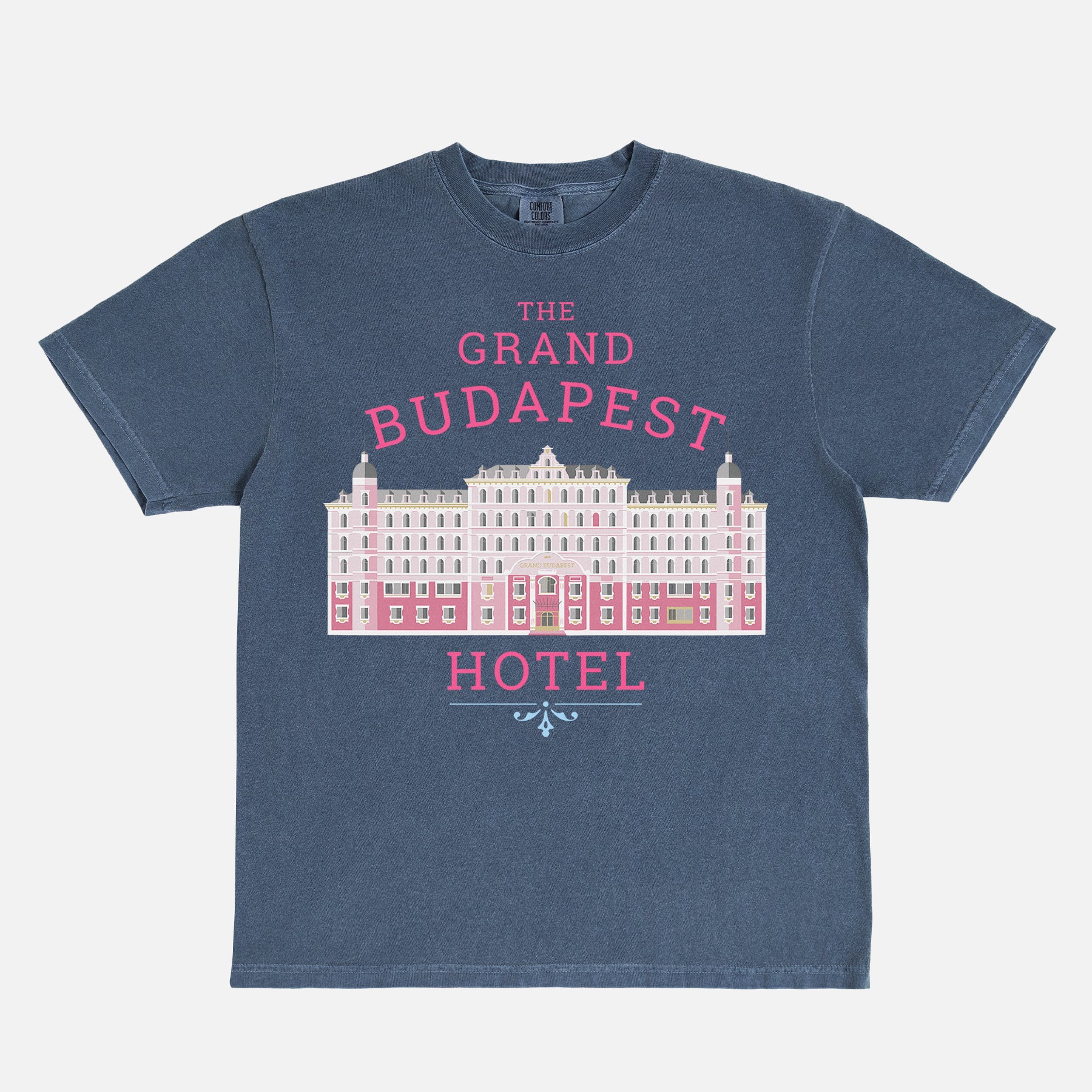 The Grand Budapest Hotel T-Shirt featuring an illustration of the iconic pink hotel façade in Wes Anderson-inspired colors on a soft unisex movie-lover graphic tee.