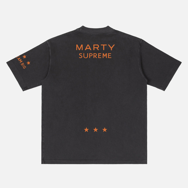 Retro Marty Supreme movie washed black graphic tee shirt with front back and sleeve print of orange movie poster logo, ping pong balls, and dream big 