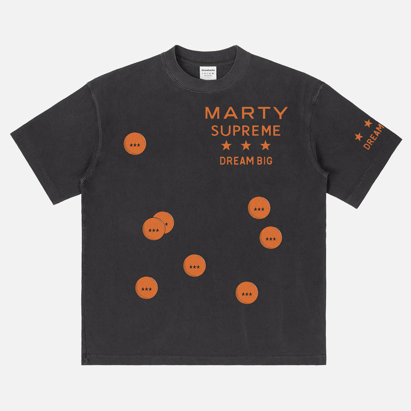 Retro Marty Supreme movie washed black graphic tee shirt with front back and sleeve print of orange movie poster logo, ping pong balls, and dream big 