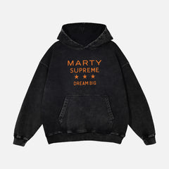 Marty Supreme hoodie distressed black heavyweight hooded sweatshirt with orange Marty Supreme Dream big text ont the front and ping pong head man in a jacket on the back