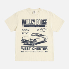 Funny Shane Gilles Tires TV Show graphic t-shirt with vintage Valley Forge Automotive center logo on a unisex beige and yellow comfort colors shirt