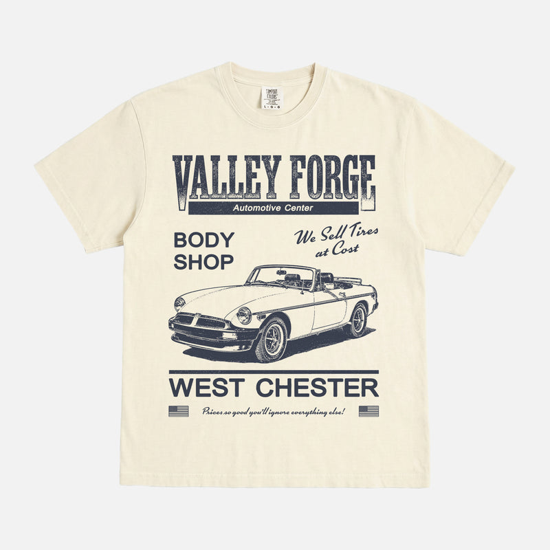 Funny Shane Gilles Tires TV Show graphic t-shirt with vintage Valley Forge Automotive center logo on a unisex beige and yellow comfort colors shirt