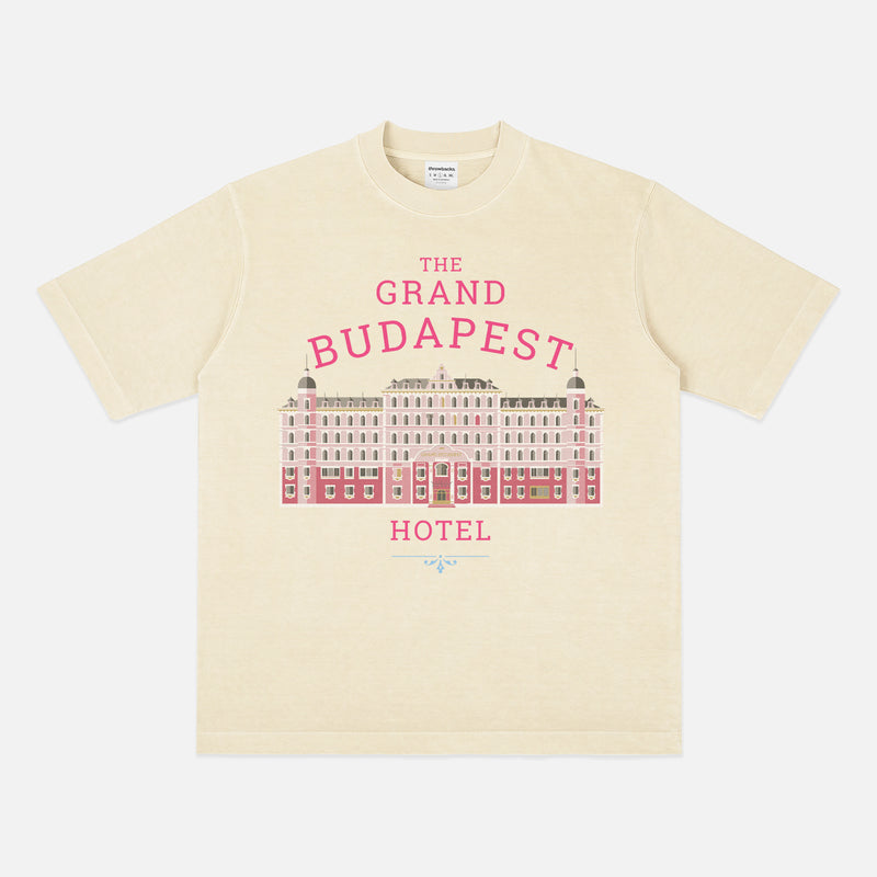The Grand Budapest Hotel T-Shirt featuring an illustration of the iconic pink hotel façade in Wes Anderson-inspired colors on a soft unisex movie-lover graphic tee.