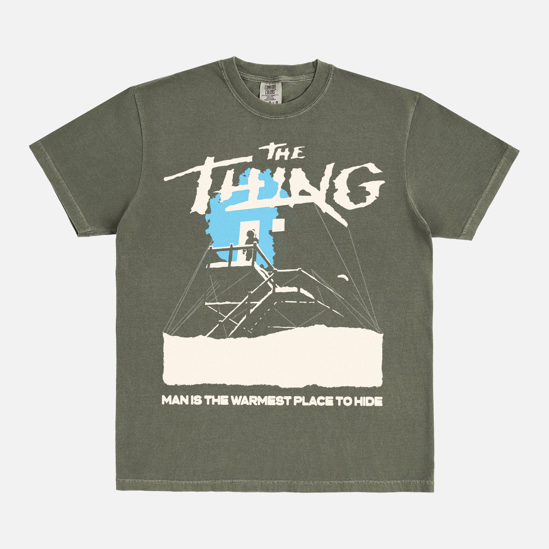 John Carpenter's The Thing 1982 graphic t-shirt with cabin snow art on a heavyweight green graphic tee